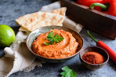 Muhammara, sağlıklı ceviz ve kavrulmuş kırmızı dolma biber sosu seramik bir kasede yassı ekmekle servis edilir.
