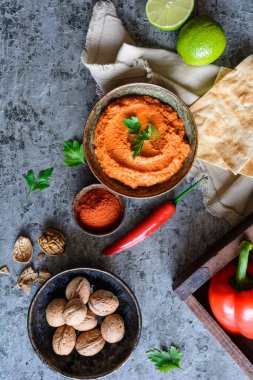Muhammara, sağlıklı ceviz ve kavrulmuş kırmızı dolma biber sosu seramik bir kasede yassı ekmekle servis edilir.