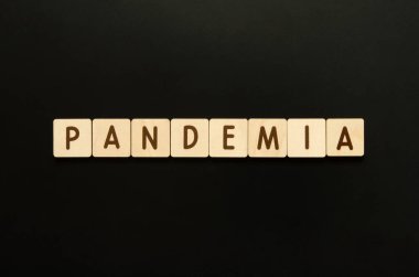 Pandemiya. Tahta bloklardan harflerle yazılmış bir kelime. Siyah arkaplanda üst görünüm. - Görüntü