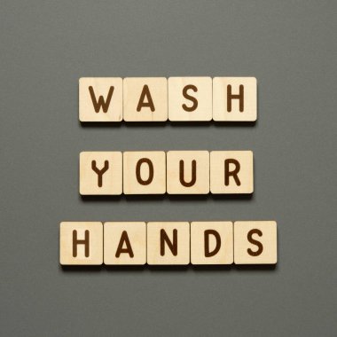 Ellerinizi yıkayın. Ahşap bloklardan harflerle yazılmış kelimeler. Gri arkaplandaki üst görünüm. - Görüntü