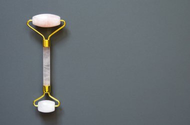 Gri arka planda pembe Gua Sha masaj aleti. Rose Quartz silindiri. Evde yüz bakımı, yaşlanmayı önleme ve kaldırma terapisi. Üst Manzara. - Görüntü