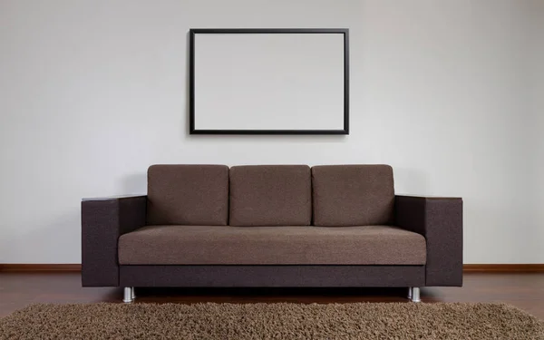 Sofá moderno con marco en blanco en la pared —  Fotos de Stock