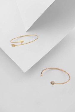 Kalp şekli ve ok, beyaz kağıtta altın bilezikler şeklinde..