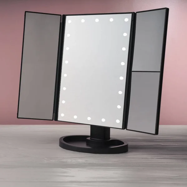 Led black vanity uzupełnić lustro na białym drewnianym stole i różowym tle — Zdjęcie stockowe