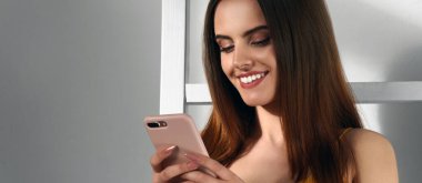 Dramatik ışık altında fotokopi alanı olan akıllı telefon kullanan bir kızın panoraması