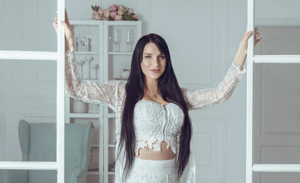 Brunette vrouw met lang haar openslaande deuren in de woonkamer — Stockfoto