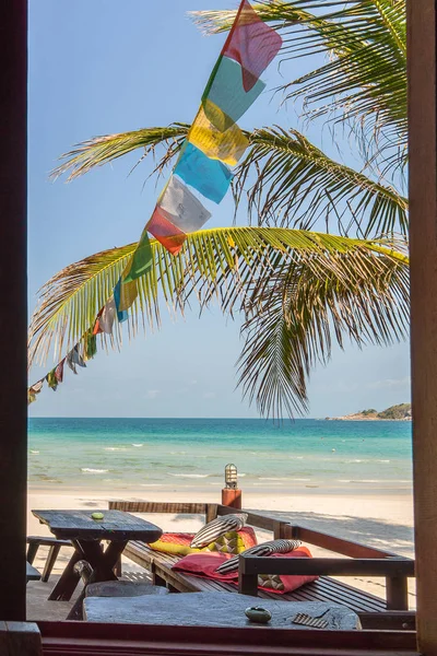 Диван и стол на тропическом пляже с пальмовыми ветвями и колоритом — стоковое фото