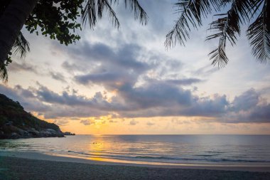 Avuç içi ile tropikal bir plaj üzerinde gündoğumu