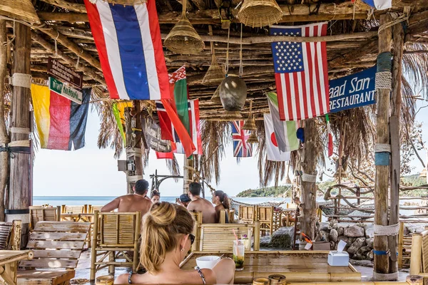 Les gens se détendent dans un bar rétro tropical sur une falaise au-dessus de la mer — Photo