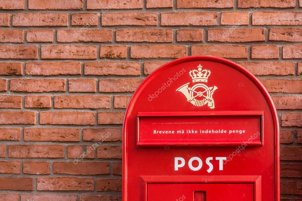 A red danish postbox on a brick wall, Denmark, 30 mars, 2018