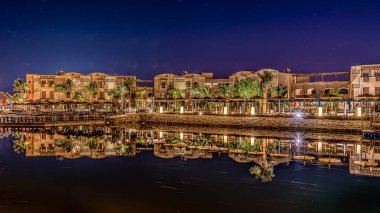Mısırlı deniz manzaralı otel ve restoranlar gece karanlığına yansıyan Gouna, Mısır, 16 Ocak 2020