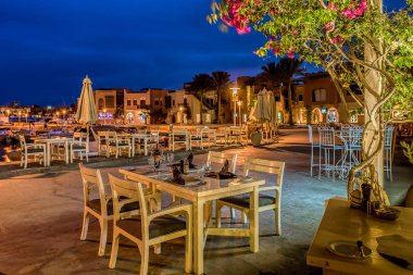 Her akşam gün batımında dört sandalyeli ve kahverengi peçeteli masa sahil yürüyüşünde, Abu Tig, el Gouna, Mısır, 14 Ocak 2020