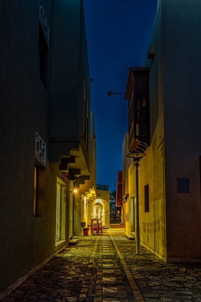 A narrow alley at night with illuminated shops and dark space for copy, el Gouna, Egypt, January 17, 2020