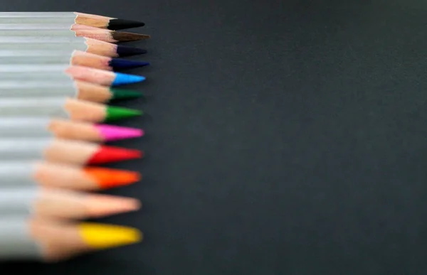 Materiales de dibujo: lápices de diferentes colores aislados sobre fondo negro — Foto de Stock