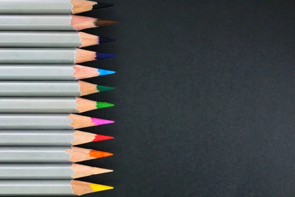 Materiales de dibujo: lápices de diferentes colores aislados sobre fondo negro — Foto de Stock