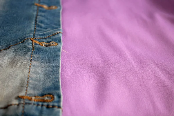 背景が紫色の生地のデニム生地 (シャツ、パンツ、ショート パンツ、ベスト) — ストック写真