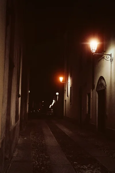 Ciudad nocturna en Italia. Novara. Calle iluminada.Tonificación Efecto Vintage. Enfoque suave — Foto de Stock