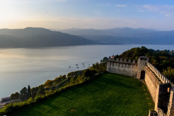 Middeleeuws kasteel op een heuvel omringd door water uit het meer Lago Maggiore. uitzicht op het kasteel van Angers en de Alpen — Stockfoto