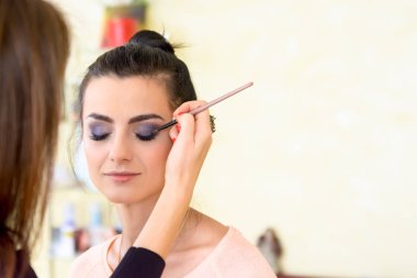Kız bir güzellik salonu makyaj yapıyor