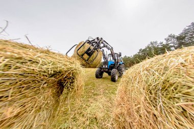 Traktör saman yığınları alanında. Tonlama