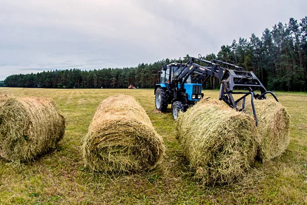 Tumpukan jerami traktor di lapangan . — Stok Foto