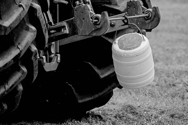 Detail kola velkého traktoru s visícími lžíce. Černobílé fotografie. — Stock fotografie