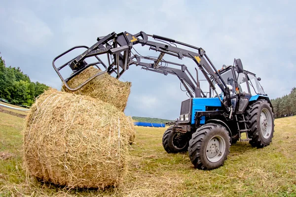 Čerkasy, Ukrajina - 16. června 2015: traktor seno zásobníky v poli. Tónování — Stock fotografie