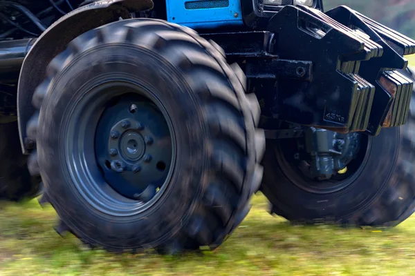 Výkonný traktor kola jdou po zemi prach. Malý pohyb efekt — Stock fotografie