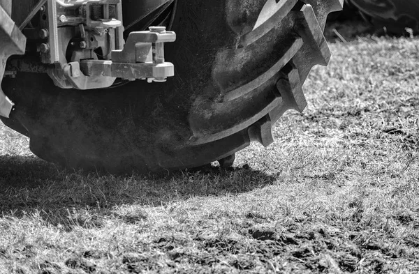 Potężny traktor koła przejść od podstaw pyłu. Efekt mały ruch. B W zdjęcie — Zdjęcie stockowe