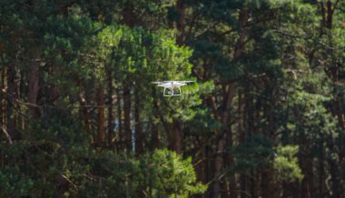 Cherkasst, Ukrayna - Haziran 17, 2016:White dron dört helikopter ile ağaçların arasında uçan yüksek çözünürlüklü dijital fotoğraf makinesi