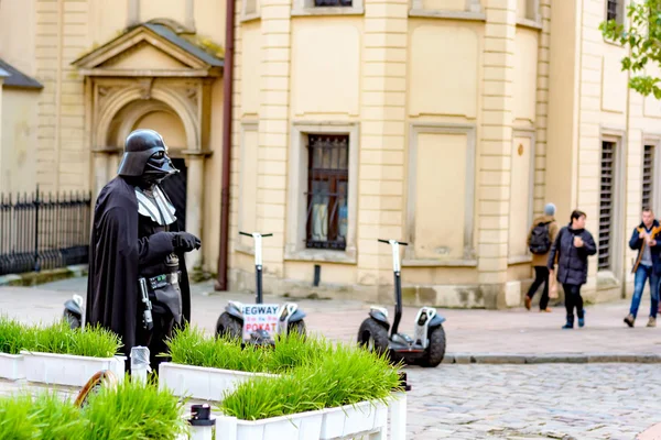Lviv, Oekraïne - 22 oktober 2016: Personage uit de Star Wars Darth Vader op de achtergrond van moderne Segway van de oude stad, straat — Stockfoto