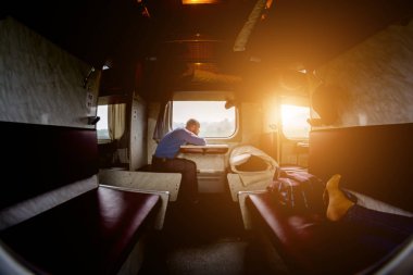 Bir adam bir treni pencerenin yakınında oturuyor. İşlem sonrası