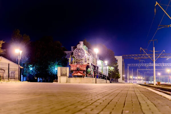 Cherkasy, Ucrânia - 21 de outubro de 2016: Velho trem a vapor vintage na estação à luz das luzes noturnas. Exposição do museu — Fotografia de Stock