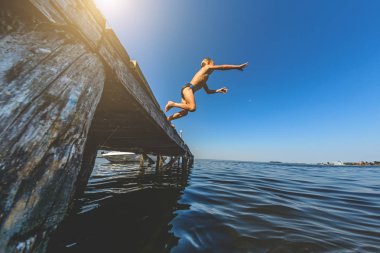 Yaz aylarında su ahşap köprü ile atlama çocuk. Tonlama