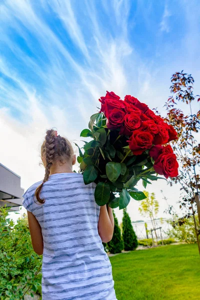 Дівчина з великим букетом червоних троянд — стокове фото
