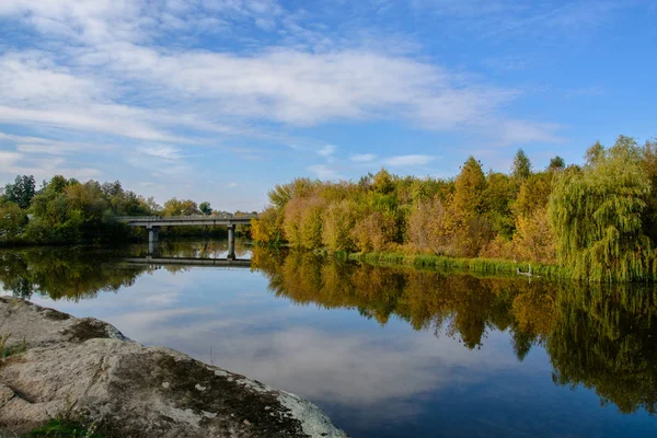 Барвистий осінній пейзаж з річкою і мостом  . — стокове фото