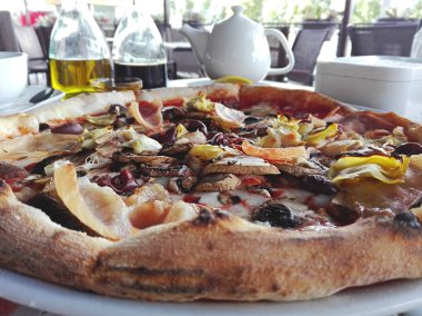 Masada hazır pizza kesmek ve yemiş.