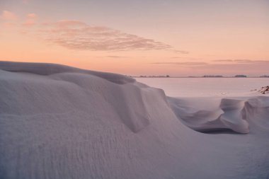 Snowdrifts ve gün batımı arka plan üzerinde kar fırtınası ile kış karlı manzara