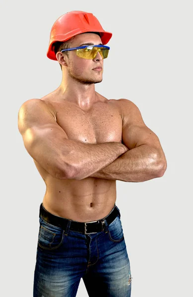 Retrato de um homem atlético em um capacete de construção vermelho e óculos. — Fotografia de Stock