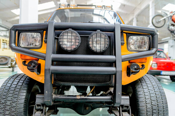 Желтый джип с защитным бампером и фарами
