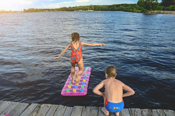 아이 들 물에서 풍선 매트리스에 점프 — 스톡 사진