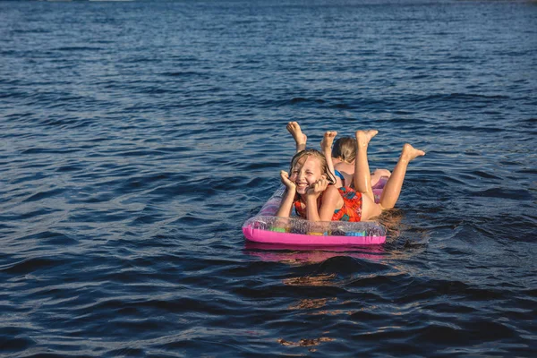 Wakacje na plaży. Dzieci pływać na materac. — Zdjęcie stockowe