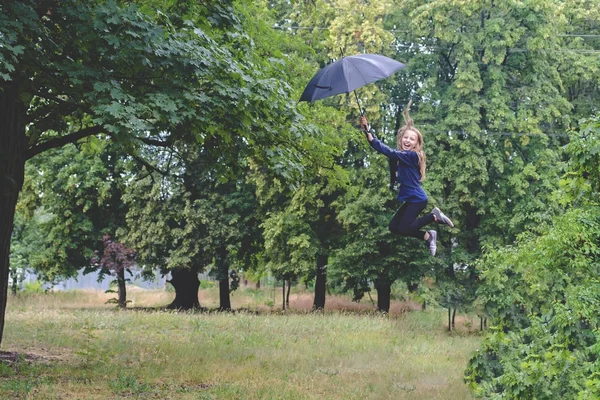 Дівчина летить з парасолькою. Після обробки — стокове фото