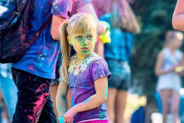 Holi tatildir. Kız kuru renklerde boyanır