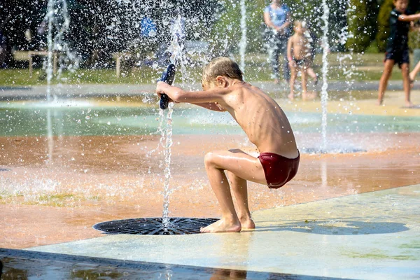 Chlapec si hraje s vodou v fountain — Stock fotografie