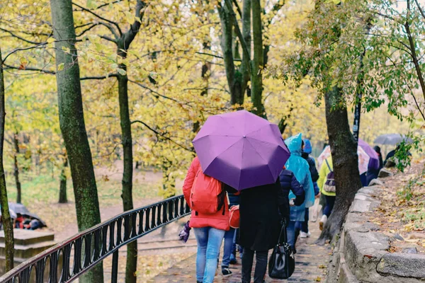 Mensen met parasols in een herfst Park. — Stockfoto