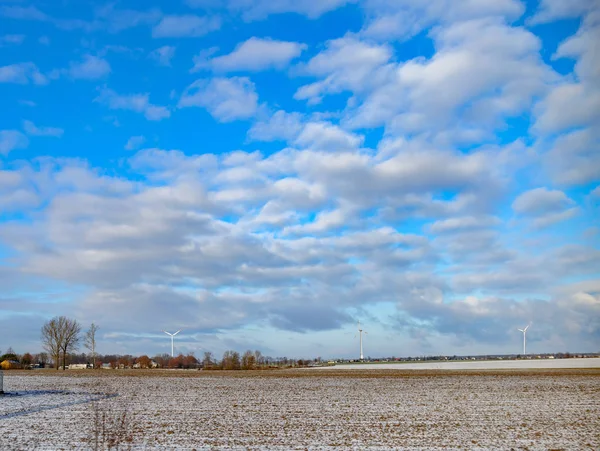Campo de invierno. En el horizonte hay generadores de energía eólica visibles . — Foto de Stock