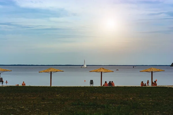 Ombrelloni di paglia sullo sfondo di acqua e yacht — Foto Stock