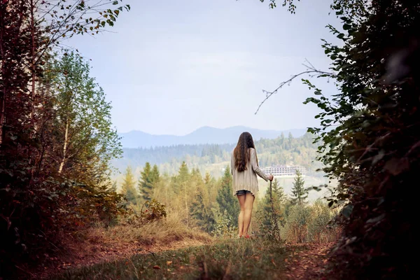 Дівчина з палицею на горі в лісі — стокове фото