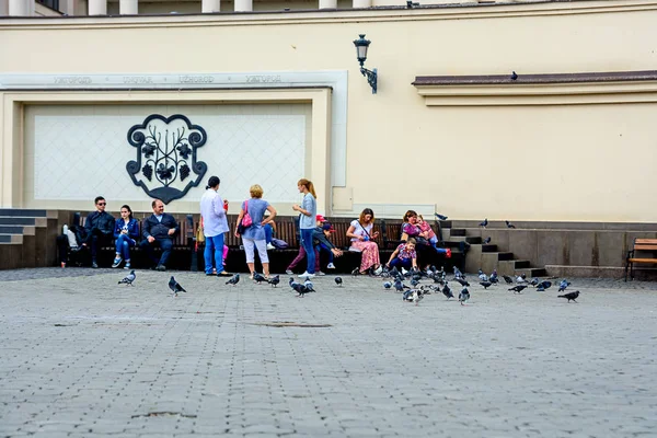 Uzhgorod, Ukrajina-18. září 2016: lidé krmím holubi na náměstí — Stock fotografie